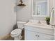 Cozy bathroom featuring a toilet, vanity with a sink, mirror, and a decorative plant at 1677 Shetland Ln, Rock Hill, SC 29730