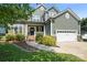 Charming two-story home featuring stone accents, a well-manicured lawn, and a two-car garage at 1677 Shetland Ln, Rock Hill, SC 29730