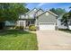 Charming two-story home featuring stone accents, a well-manicured lawn, and a two-car garage at 1677 Shetland Ln, Rock Hill, SC 29730