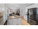 Spacious kitchen with an island, stainless steel refrigerator, and hardwood floors leading to dining area at 1677 Shetland Ln, Rock Hill, SC 29730