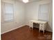Inviting bedroom featuring wood floors, built-in desk, and natural light from the windows at 180 Tower Rd, Troy, NC 27371