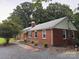 A well-kept red brick home with a lovely yard and lush landscaping; a serene and inviting setting at 180 Tower Rd, Troy, NC 27371