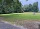 Open green space with a mature tree, promising a serene and expansive outdoor environment at 180 Tower Rd, Troy, NC 27371