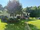 Delightful single story home with lovely front garden, quaint porch, and green lawn at 201 N Ferry St, New London, NC 28127