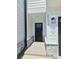 Modern front door with black hardware, stone accents, and a contemporary light fixture with house numbers at 2137 Barrowcliffe Dr # 49, Concord, NC 28027