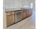 Kitchen island with stainless steel dishwasher, granite countertops, and wood cabinets at 2137 Barrowcliffe Dr # 49, Concord, NC 28027