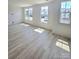 Bright living room featuring light wood-style flooring and multiple windows at 2137 Barrowcliffe Dr # 49, Concord, NC 28027