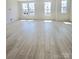 Spacious living room with wood-style flooring and natural light from multiple windows at 2137 Barrowcliffe Dr # 49, Concord, NC 28027