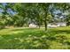 Lush backyard with mature trees, single-story house, shed, and green grass, ideal for enjoying the outdoors at 2488 Catawba Church Rd, Rock Hill, SC 29730