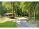 Gravel driveway and covered parking area surrounded by mature trees and landscaping at 2615 Highway 557 None, Clover, SC 29710