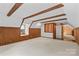 Spacious attic area featuring beamed ceiling, wood paneled walls, and neutral carpeting at 265 River Run Rd, Statesville, NC 28625