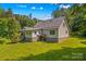 Backyard view reveals a home with light siding, a metal roof, and well-kept lawn at 265 River Run Rd, Statesville, NC 28625