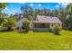 Backyard features a spacious lawn and a covered porch perfect for relaxing and entertaining at 265 River Run Rd, Statesville, NC 28625
