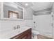 Bathroom featuring white wainscoting, dark vanity, and large mirror at 265 River Run Rd, Statesville, NC 28625