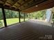 Spacious covered back porch featuring railings and wood decking, with view to backyard at 265 River Run Rd, Statesville, NC 28625