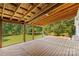 Expansive wood deck features a covered area with wooden beams and a view of the surrounding greenery at 265 River Run Rd, Statesville, NC 28625