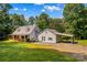 Well-maintained home boasts a wraparound porch, metal roof, an attached carport, and a tree-lined yard at 265 River Run Rd, Statesville, NC 28625