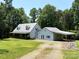 Traditional style home featuring a metal roof, covered porch, attached carport and spacious yard at 265 River Run Rd, Statesville, NC 28625