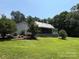 Traditional style home featuring a metal roof, covered porch, and lush landscaping at 265 River Run Rd, Statesville, NC 28625