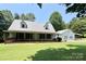 Charming single Gathering home featuring a metal roof, covered porch, and attached carport on a lush green lawn at 265 River Run Rd, Statesville, NC 28625