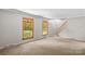 Bright living room features large windows, stairs, and light colored carpet at 265 River Run Rd, Statesville, NC 28625