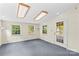 Bright living room features neutral walls, plush carpeting, and ample natural light through multiple windows at 265 River Run Rd, Statesville, NC 28625