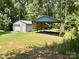 Metal outbuilding with covered carport and garage door, perfect for storage or workshop space at 265 River Run Rd, Statesville, NC 28625