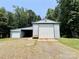 Metal outbuilding with multiple garage doors and adjacent carport, ideal for vehicle and equipment storage at 265 River Run Rd, Statesville, NC 28625
