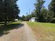 A picturesque property featuring a long driveway leading to a charming home and a spacious outbuilding at 265 River Run Rd, Statesville, NC 28625