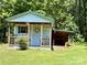 Cozy Shed featuring covered porch, unique design details, and picturesque landscaping at 265 River Run Rd, Statesville, NC 28625