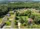 Aerial view of several homes in a residential neighborhood surrounded by mature trees and green lawns at 2906 Plantation Way, Albemarle, NC 28001
