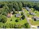 Aerial view of a home with mature trees in a residential neighborhood with a pool in the distance at 2906 Plantation Way, Albemarle, NC 28001