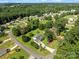 Aerial view of a home with a gray roof, green lawn and mature trees in a quiet residential neighborhood at 2906 Plantation Way, Albemarle, NC 28001