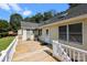 Wooden deck with white railings, offering outdoor living space with seating and views of the surrounding greenery at 2906 Plantation Way, Albemarle, NC 28001