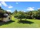 Expansive backyard featuring a well-maintained lawn, outbuilding, and mature trees, offering a serene outdoor space at 2906 Plantation Way, Albemarle, NC 28001