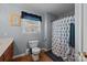 Cozy bathroom featuring a toilet, shower with patterned curtain, and a window with blue accents at 2906 Plantation Way, Albemarle, NC 28001