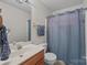 Clean bathroom featuring a sink, toilet, and shower with a light blue shower curtain for privacy at 2906 Plantation Way, Albemarle, NC 28001