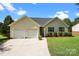 Single Gathering home featuring a well-manicured lawn and a two car garage on a sunny day at 2906 Plantation Way, Albemarle, NC 28001