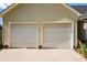 Spacious two-car garage featuring white doors and neutral siding, with brick accents and a clean concrete floor at 2906 Plantation Way, Albemarle, NC 28001