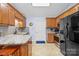 Bright kitchen features wood cabinetry, granite counters, stainless appliances, and tile flooring at 2906 Plantation Way, Albemarle, NC 28001