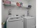 Well-equipped laundry room featuring a washer, dryer, and shelving for laundry supplies at 2906 Plantation Way, Albemarle, NC 28001
