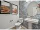 Stylish powder room featuring a unique tile wall, pedestal sink, and modern fixtures at 3134 Beacon Heights Rd, Indian Land, SC 29707