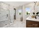 A bright bathroom boasts a double vanity, a large mirror, marble floors, and a glass-enclosed shower at 327 Ardmore Dr, Belmont, NC 28012