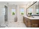 A bright bathroom boasts a double vanity, a large mirror, marble floors, and a glass-enclosed shower at 327 Ardmore Dr, Belmont, NC 28012