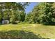 Expansive backyard featuring shed with lush green grass and mature trees, perfect for outdoor activities and privacy at 4030 Orion Rd, York, SC 29745