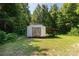 Backyard shed with a covered extension and double doors, nestled amongst lush greenery and trees at 4030 Orion Rd, York, SC 29745