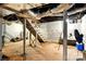 Unfinished basement with white walls, open ceiling, cement flooring, and stairs to upper level at 450 1St Se St, Hickory, NC 28602