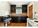 Kitchen featuring dark cabinets, hardwood floors, and modern appliances like the white oven at 450 1St Se St, Hickory, NC 28602