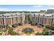 Aerial view of buildings surrounding a round, decorative fountain and lush landscaping at 4625 Piedmont Row Dr, Charlotte, NC 28210