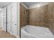 Bathroom featuring a soaking tub with tiled walls, shower, and double doors at 4625 Piedmont Row Dr, Charlotte, NC 28210